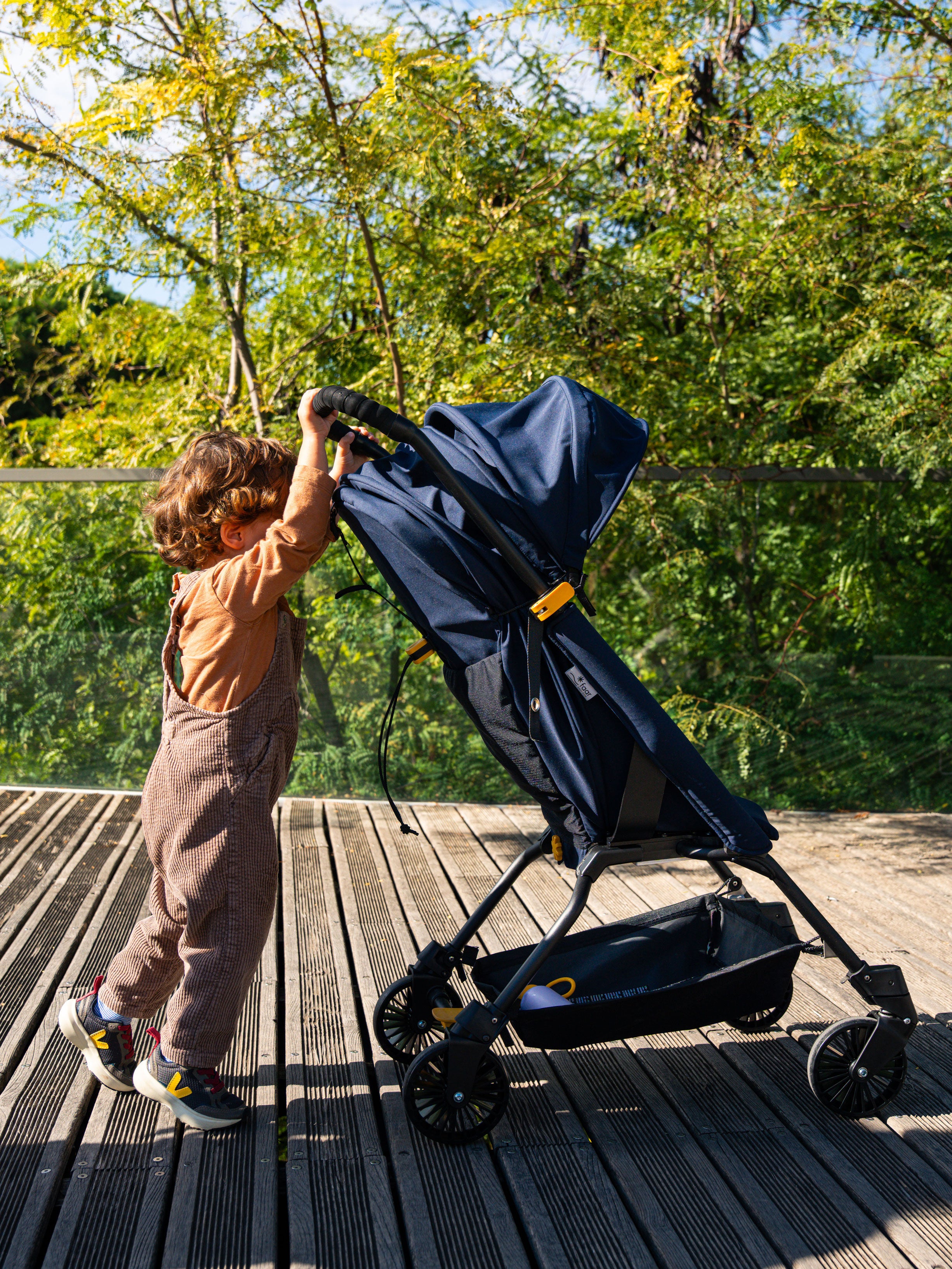 Enfant les mains sur le guidon du FAAR Ride en mode poussette