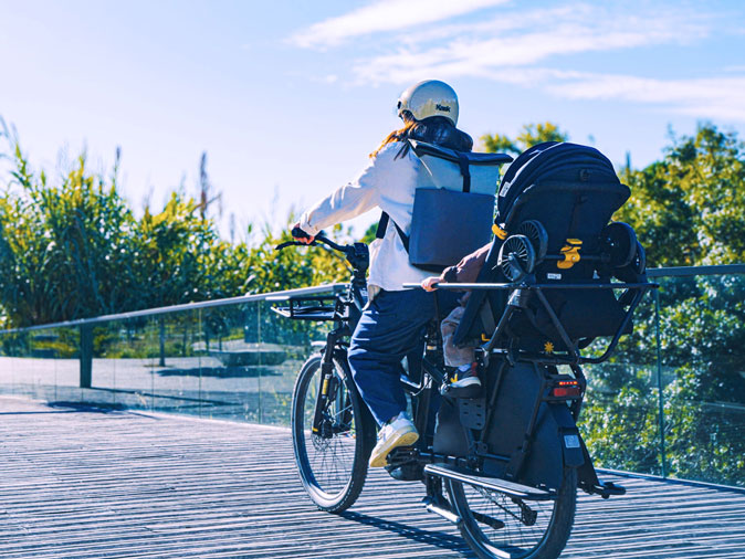 FAAR Ride sur le vélo avec un enfant dans un paysage vert et urbain